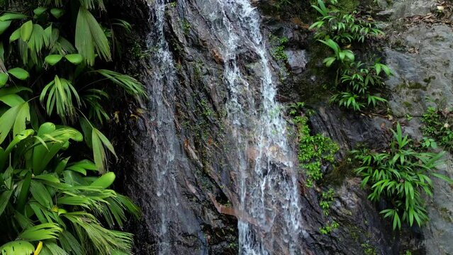 4K Drone shot of a small jungle waterfall surrounded by plants and rocks, without people in the touristic village of Minca, close to Santa Marta in Colombia.