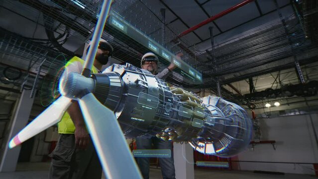 Two male workers in VR headsets watch details of wind turbine at factory using 3D hologram. 3D render of virtual wind mill. Modern and digital electric generation system. Green energy and wind power.