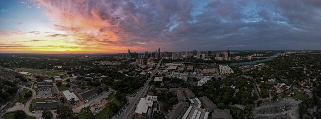 Drone panoramic shot of Austin cityscape under cloudy sky at dusk in Texas - Powered by Adobe