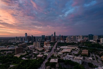 Naklejka na ściany i meble Drone shot of Austin cityscape under cloudy sky at dusk in Texas