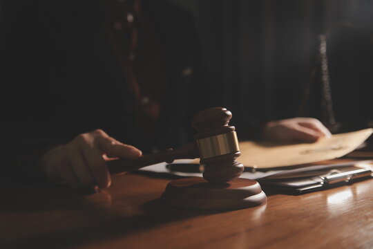 law books and scales of justice on desk in library of law firm. jurisprudence legal education concept.