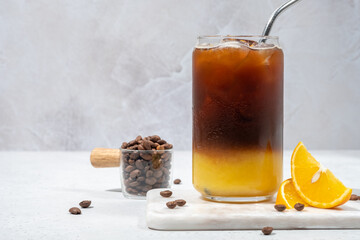 Bumble coffee mix with orange juice and cold brew coffee with ice. Summer trendy refreshing coffee drink.