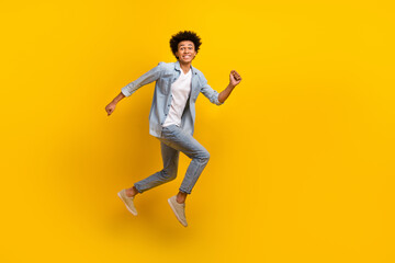 Fototapeta na wymiar Full length profile photo of cheerful active man jumping running isolated on yellow color background