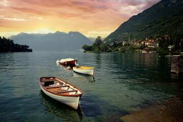 Beautiful scene of boats on lake Como in Italy. A big blue lake surrounded by green hill.