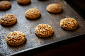 Oatmeal cookies on baking sheet. Fresh sweet pastries for tea. Homemade oatmeal sweets.
