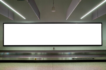 Long wide blank white advertisement board mockup template on the wall by a luggage carousel in an...