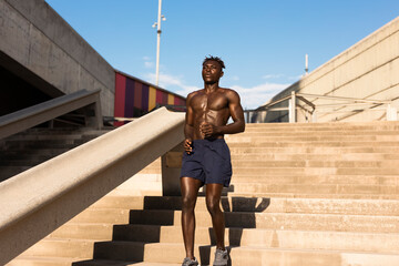 Fitness training outdoors. Handsome African man running. Muscular man training..