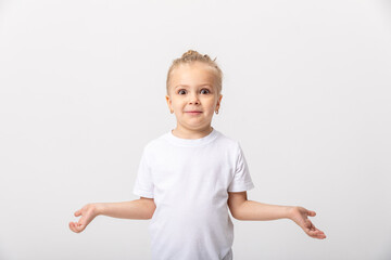 Confused doubtful shocked little girl shrugging feel baffled looking at camera on white blank studio background, cute child puzzled stunned. I dont know concept.