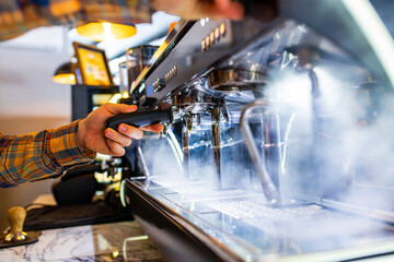 Professional barista young redhaired ginger bearded man in black apron working in coffee shop