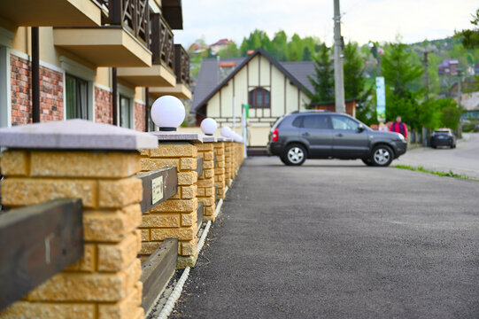 A car is parked in an empty parking lot in a small town near a hotel. paraphrase