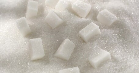 Sugar Cubes on the Surface of White Sugar macro. Close up. Slow motion. Hard pieces of sugar crumble in a pile of granulated sugar. Granules. Texture, abstract background. Particles. Diabetes.