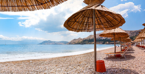 Sunshade and deck chair on beach at Baska in Krk - Croatia