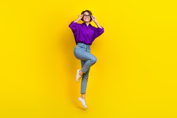 Fototapeta na wymiar Full body cadre of young nice lady business employee wear purple shirt denim jeans touch glass jump isolated on yellow color background