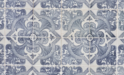 Vintage ceramic tiles of faded blue colour with floral repetitive ornate in Lisbon, Portugal....
