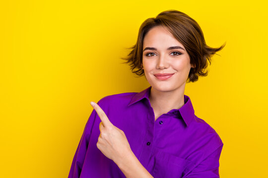 Photo of charming girl worker cheerful smile direct finger empty space wear elegant violet blouse isolated yellow color background