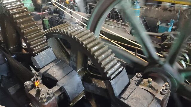 4K footage of a large engine transmission driving a sugarcane mill, showcasing powerful rotating gears and mechanical motion in industrial detail.