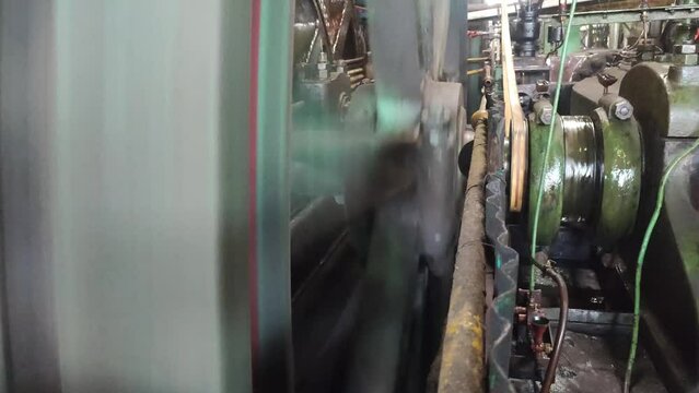 4k video of Steam engine powering sugar cane milling in a sugar factory.