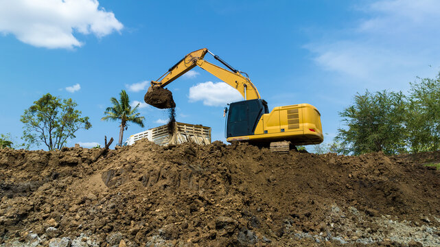 excavating soil into a dump truck to build a pond for store water for use in the dry season for agriculture