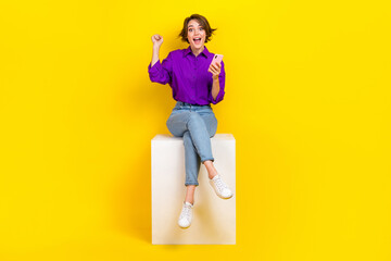Full length photo of pretty lucky woman dressed purple shirt winning game modern device isolated...