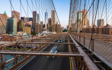 Fototapeta premium Moving cars on the Brooklyn Bridge in the New York City in the morning dawn.