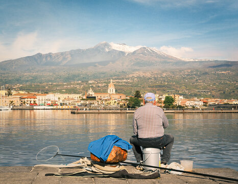 View of the village of Riposto from the harbor and Volcano Etna in the background