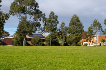 house in the parkVacant green grassy sports ground in a public local park in an Australian suburban...