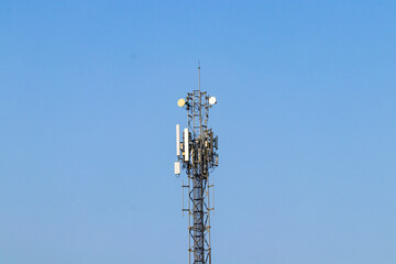 Wireless Communication Antenna Transmitter with antennas bright sunlight and sky background. Telecommunication tower 4G, 5G cellular Base Station or Base Transceiver Station. Telecommunication tower 