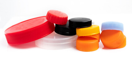 A pile of plastic bottle caps and jars isolated on white. Recyclable trash