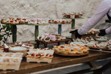 Waiter prepare holiday buffet table served by different snacks ready for eating in restaurant