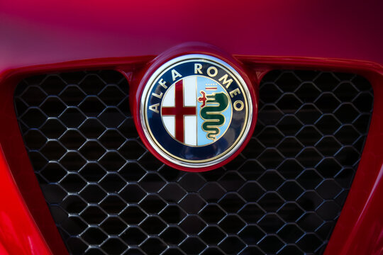 Close-up shot of the Alfa Romeo brand logo on the front radiator grille of a classic luxury sports car
