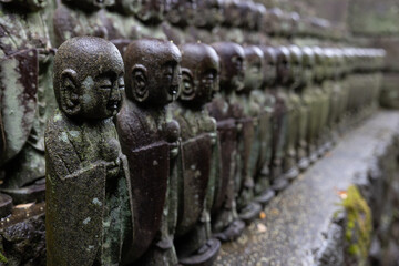 stone statues of Ksitigarbha bodhisattva (Jizo) at Hasedera Temple, Kamakura, Japan on a rainy day