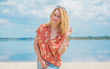 Woman in colorful cotton fashionable shirt and flared jeans. Trendy clothes, vacation concept. Style 70s