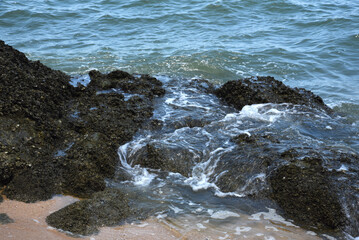Felsenküste, wellen brechen sich an Felsen