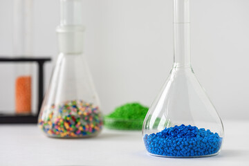 Plastic factory laboratory. Glass flasks with colored dye in granules for plastics. polymer...