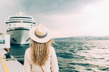 Woman tourist standing in front of big cruise liner, travel female