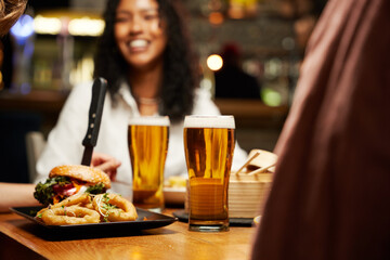 Close-up of young multiracial group of friends in casual clothing enjoying dinner at bar