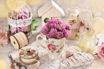 Fototapeta na wymiar Red clover flowers in a cup on vintage style table