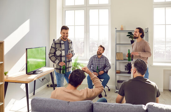 Portrait Of Mature Bearded Male Friends Discussing And Talking With Each Other During Watching Sport Football Match On Tv With Beer Together At Home. Friendship, Leasure, Sport, Home Party Concept.