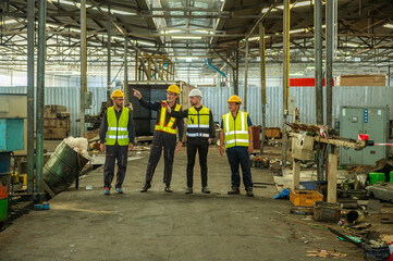 Group of engineer foreman walk line of troops straight in and talk together at end time of work in old Factory. unity teamwork colleague foreman and trainee walk straight in and talk collaboration.