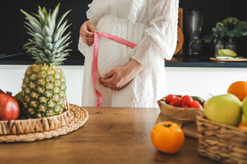 Pregnant woman measure her extended waist by using a meter. Pregnant concept