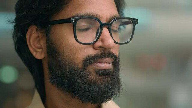 Handsome bearded Muslim businessman in glasses Arabian professional financial advisor man Indian executive pensive thinking manager entrepreneur in office looking to side at camera business portrait