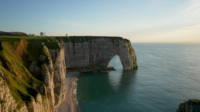 Panoramic view of beautiful cliffs of Aval door by Etretat in France on evening at sunset. Scenic view of amazing amazing white chalk cliffs in Upper Normandy. Magnificent view on Manneport Arch.