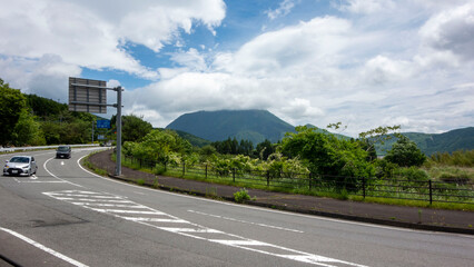大分県由布院水分峠から梅雨の晴れ間に山頂が雲に隠れた由布岳を望む。View of Mt. Yufu, the summit of which is hidden by clouds, during the rainy season from Yufuin Mizuwake Pass, Oita Prefectur。