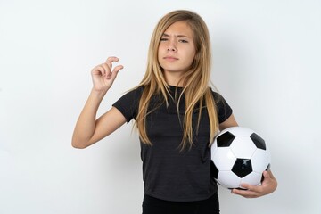 Displeased beautiful caucasian teen girl wearing sportswear  over white wall shapes little hand...