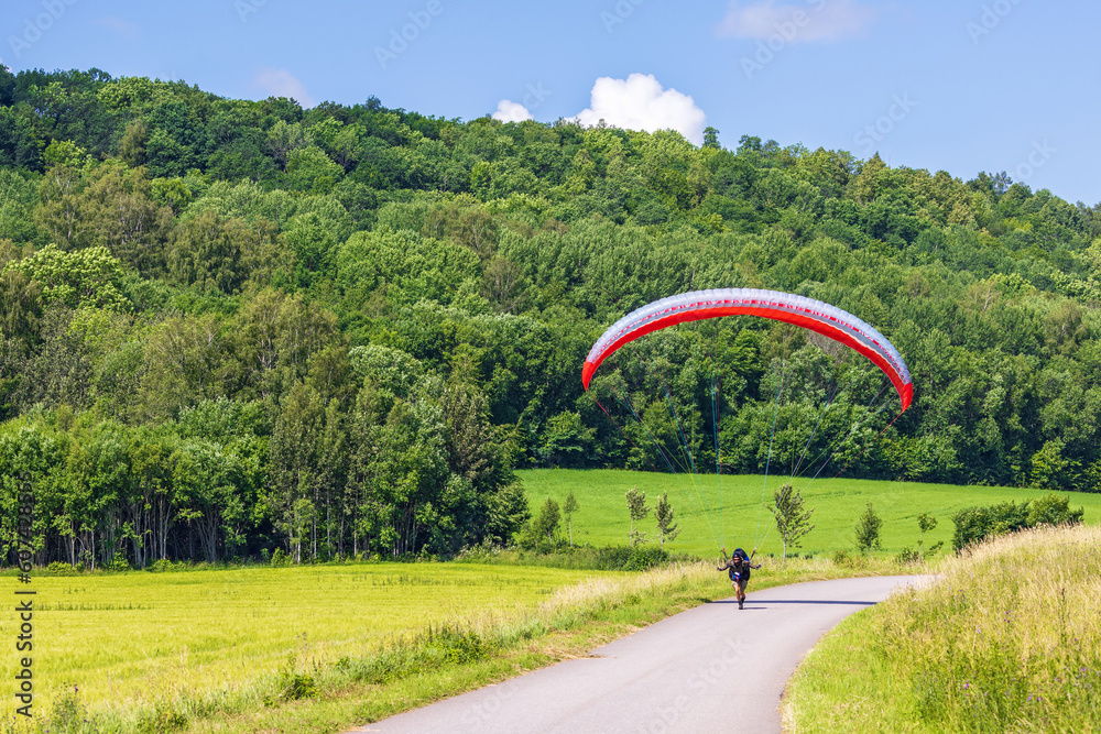 Wall mural Paraglider on a country road