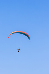 Paraglider flying at a blue sky