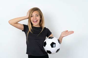 Shocked amazed surprised beautiful caucasian teen girl wearing sportswear  over white wall hold hand offering proposition