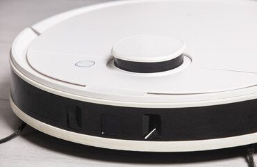 A robot vacuum cleaner at home on the floor.Helper at home. Lifestyle.	