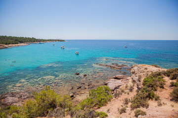 Ships on the horizon over a sparkling crystal blue sea water. Beauty of nature untouched coast is a perfect travel destination. Peaceful summer day on the Greek coast.