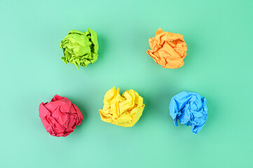 Crumpled paper balls on a green background.